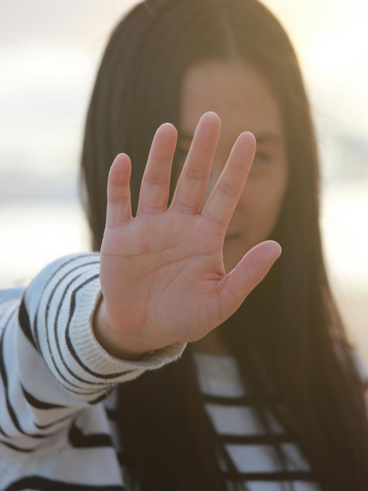 A woman holding up her hand, symbolising protection and safety
